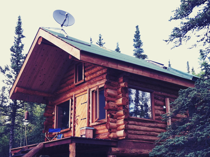 Cabin in Alaska with a satellite internet dish on the roof