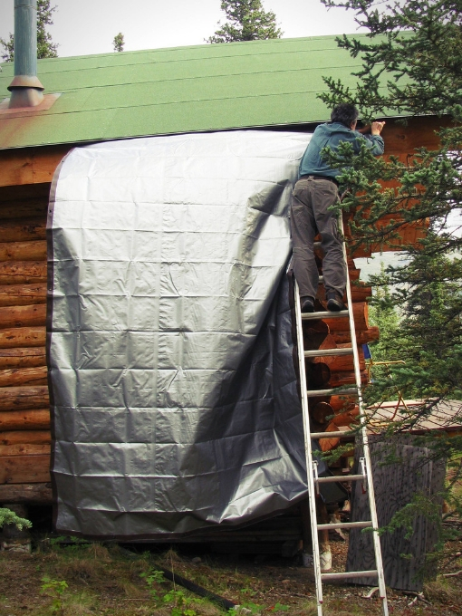 Rigging up a tarp to catch rain water from the roof